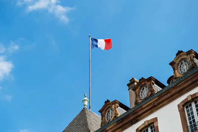 Флаг Франции на флагштоке на крыше фото