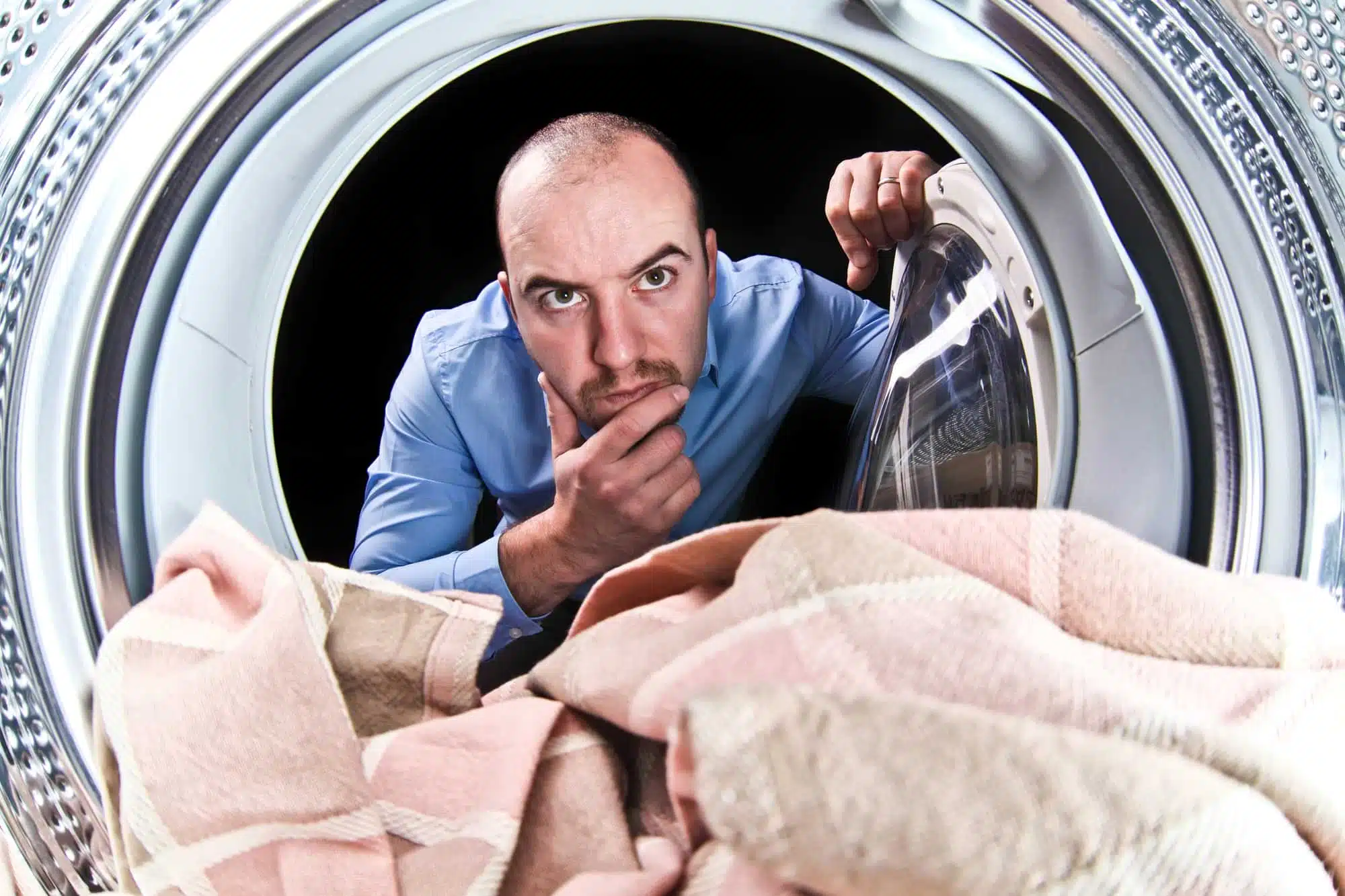 Мужчина возле стиральной машины фото