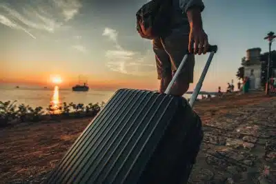мужчина катит чемодан фото
