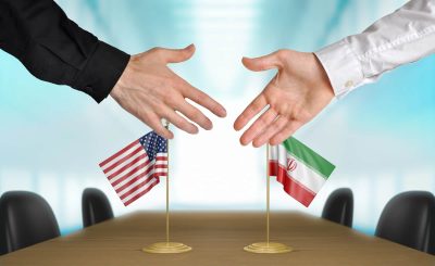 Человеческие руки на фоне флагов США и Ирана фото