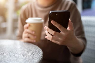 Женщина держит в руке смартфон iPhone фото